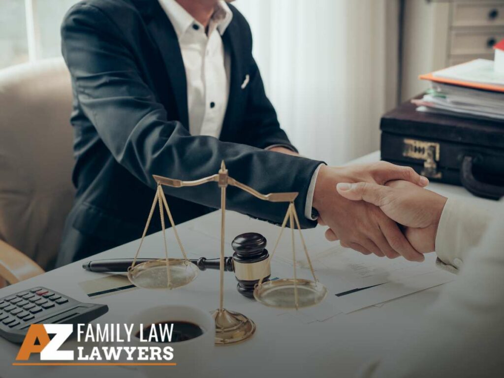 Lawyers shaking hands over a desk with legal scales, representing professional collaboration in child custody cases