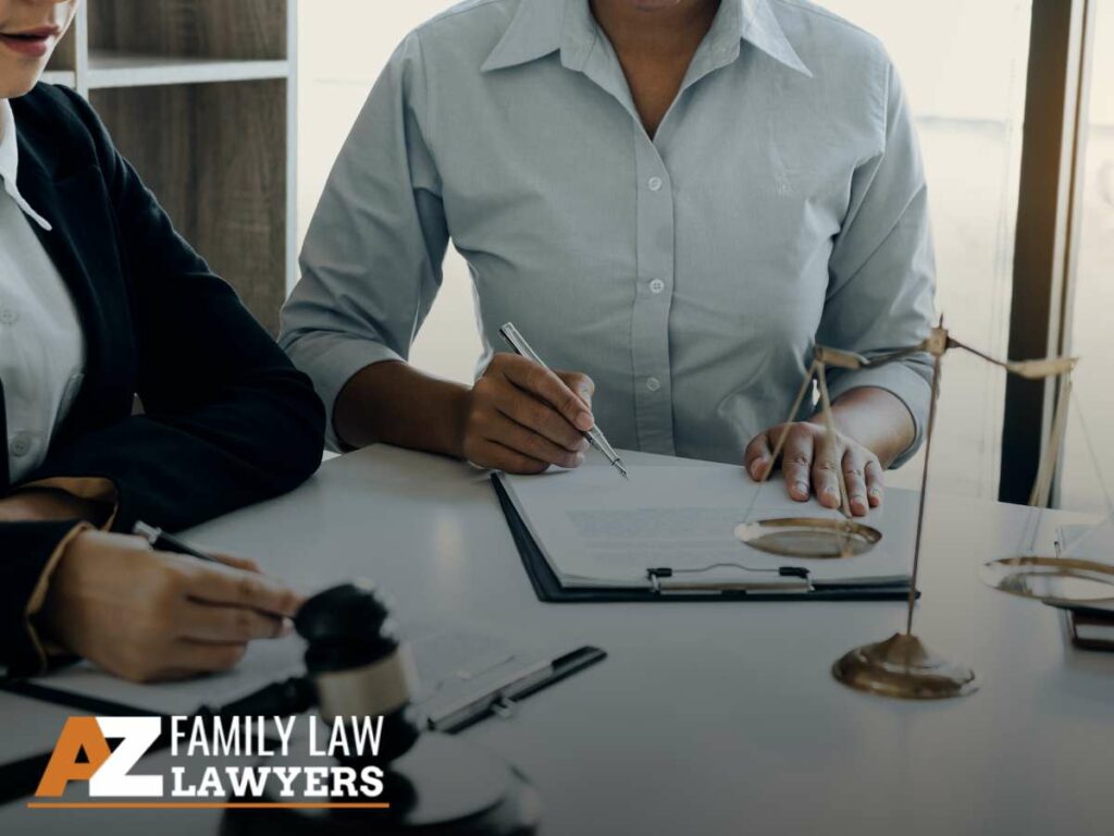 Arizona Family Attorneys discussing legal documents with scales of justice on the table.