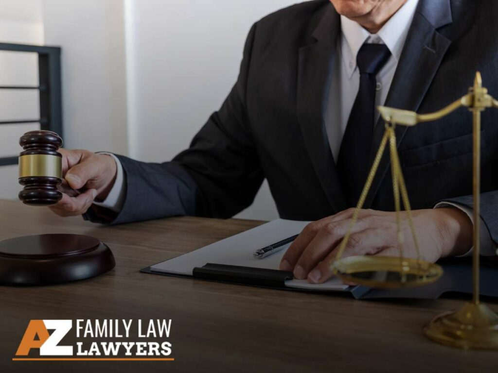 Attorney holding a gavel in a divorce case with a legal scale on the desk.
